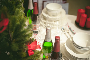 Obraz na płótnie Canvas festive table appointments. Christmas table layout, preparation for celebration. Round table covered with tablecloth with an ornament on table arranged plates, dishes, knives, forks, glasses, drinks.