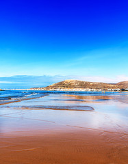 Der breite kilometerlange Strand von Agadir gegenüber Kasbah Berg mit dem Schriftzug: Gott, Vaterland, König 
