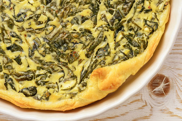 Tart with spinach and eggs on white background.