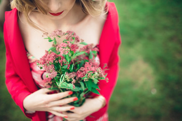 young lady holding a bouquet of red flowers