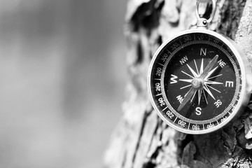 Black and white photo of an old compass in retro style / tourist compass closeup