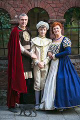 Beautiful family in medieval clothes posing in old town