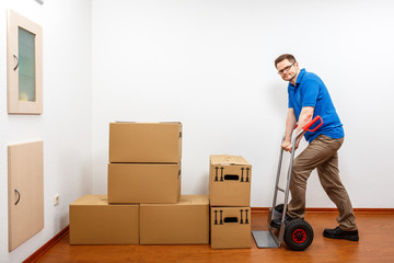 Mann packt Kartons auf eine Sackkarre