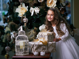 Beautiful toothless girl in  white dress enjoys the gifts