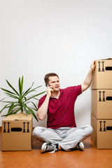 Mann sitzt auf dem Boden und diskutiert per Smartphone