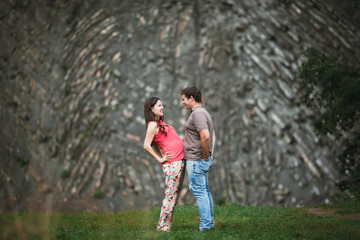 Fototapeta premium Beautiful pregnant woman with her husband posing outside