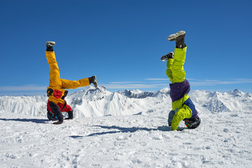 Two snowboarders are on hand upside down in high mountains © Аrtranq