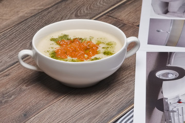 Salmon cream-soup on wooden table