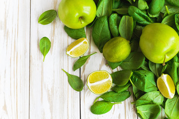 Wooden backgroung with healthy green spinach, lime and apple