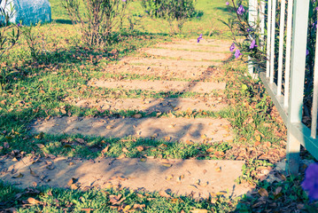 Stone walkway with green grass in the park. Vintage filter style