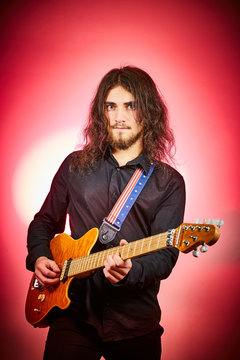 Ragazzo suona chitarra metal su fondo rosso