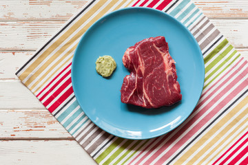 Raw steak on wooden table