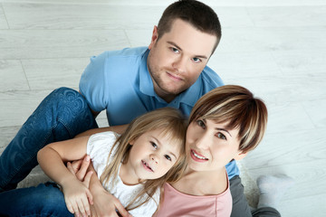 Fototapeta premium happy family mother, father and two children playing and cuddling at home on floor. Unusually view from above.