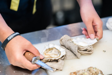guy shucking an oyster with his bare hands
