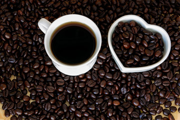 cup of coffee with pile of coffee bean , coffee lover concept