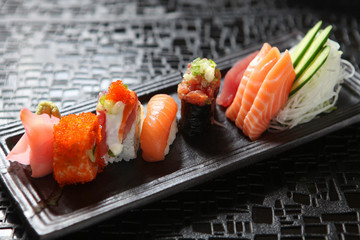 Japanese sushi roll on a black plate