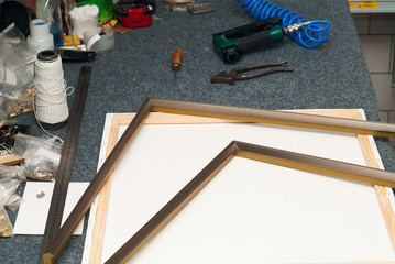 Craftsman working on frame in frame shop. Professional framer hand holding frame angle. Top view....