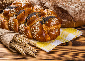 Assortment of baked bread on wooden table background