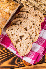 Fresh bread slice and cutting knife on rustic table