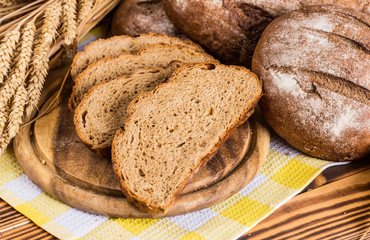 Assortment of baked bread on wooden table background
