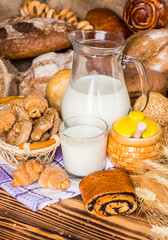 Assortment of baked bread on wooden table background