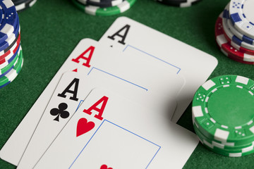 Playing cards and poker chips on green table