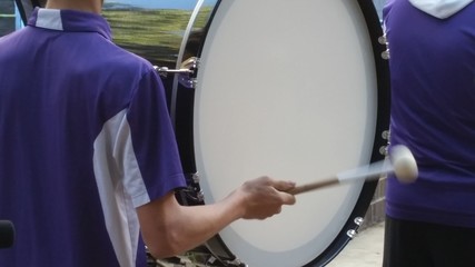 Drummer at a Parade Drumming on a Bass Drum in a Marching Band