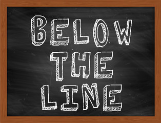 BELOW THE LINE handwritten text on black chalkboard