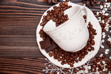 Coffee cup and beans on wooden background.