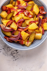 Homemade potato salad with bacon and pickles.