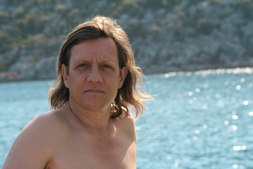 Мужчина с длинными волосами на море