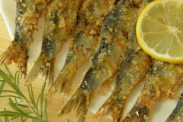 Salted anchovy with lemon and rosemary on plate