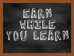 EARN WHILE YOU LEARN handwritten text on black chalkboard