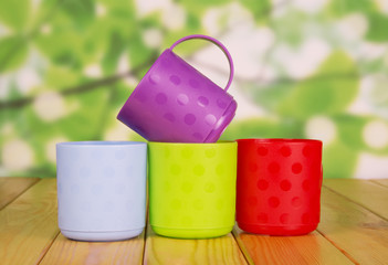 Four plastic mug on abstract green.
