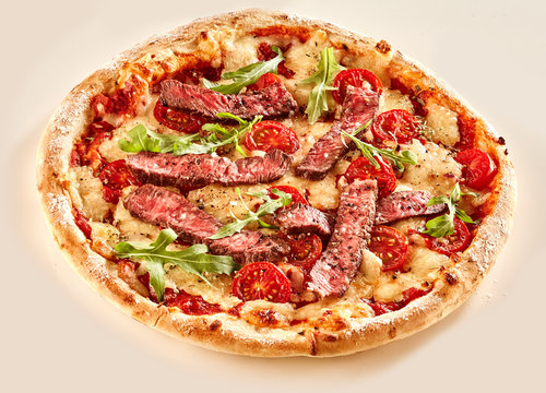 Beef pizza with tomato and arugula