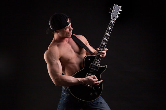 topless man  emotionally playing guitar