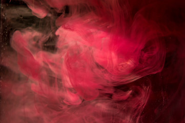 Red orange ink in water. Sunshine lighting. Dynamic movement of