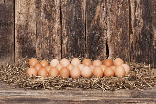 Egg in hay on old wooden background