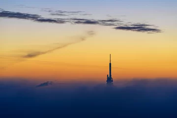 Fototapeten Zizkov Television Tower at sunrise with big fog cloud and amazing sky. Prague. Czech Republic. © marekkijevsky