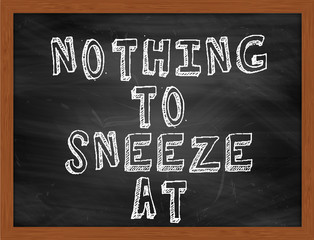 NOTHING TO SNEEZE AT handwritten text on black chalkboard