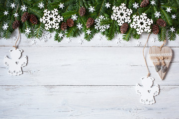 Christmas wooden background with branches, trees, cones, snowflakes and angel