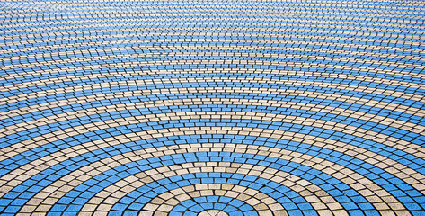 Fototapeta na wymiar Decorative colorful sidewalk pavement. Tiled floor with yellow and light blue tiles, full frame background pattern.
