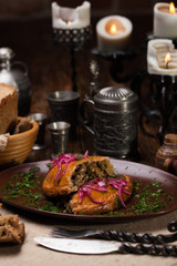 Meat pies, on top of a red onion and sauce