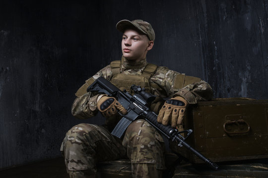 The soldiers - our pride. Special forces soldier with rifle on dark background.