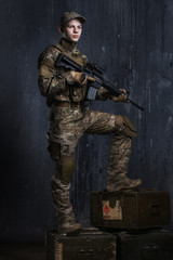 Fototapeta premium Young men standing on boxes with a rifle. Confident and proud look