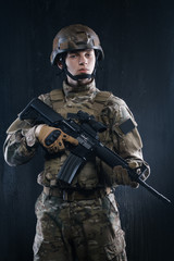 Proud soldier with his head held high holding a gun and looking confidently forward.