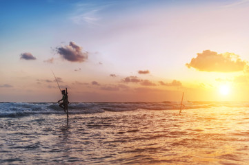 silhouette of fisherman on sunset with beautiful dramatic sky