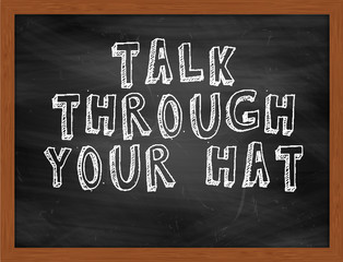 TALK THROUGH YOUR HAT handwritten text on black chalkboard