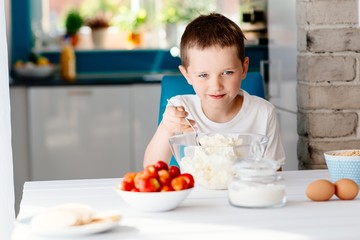 The boy mixing white cheese in bowl for cheesecake