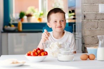 Boy mixing white cheese in bowl for cheesecake